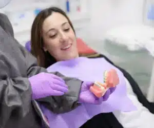 Dentist explaining orthodontic treatment using a dental model to a patient